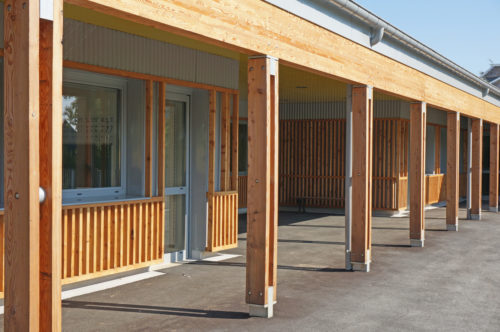Extension et rénovation du groupe scolaire de Berville, par Atelier Cosme Architecture. Vue de la galerie-préau en bois.