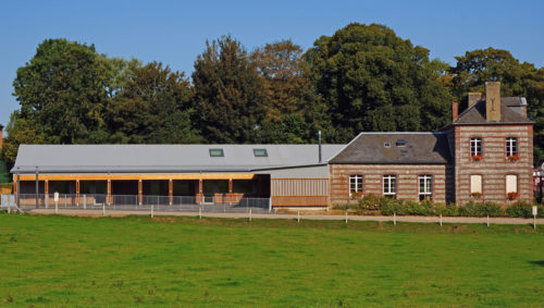 Extension et rénovation du groupe scolaire de Berville, par Atelier Cosme Architecture. Vue d'ensemble, avec la construction neuve adossée à la mairie.