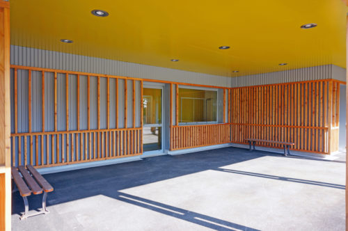 Extension et rénovation du groupe scolaire de Berville, par Atelier Cosme Architecture. Vue du préau et de ses jeux d'ombre au sol.