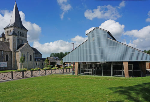 Garage et city-stade d'Alvimare par Atelier Cosme Architecture. Structure bois, façade bois, et volumes répondent à l'église.