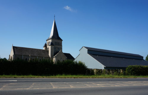 Garage et city-stade d'Alvimare par Atelier Cosme Architecture. Structure bois, façade bois, et volumes réinterprètent l'architecture agricole environnante.