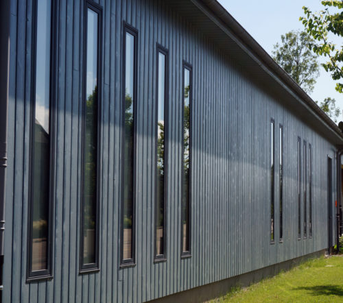Garage et city-stade d'Alvimare par Atelier Cosme Architecture. Structure bois, façade bois, et volumes jouent avec les échelles domestiques.