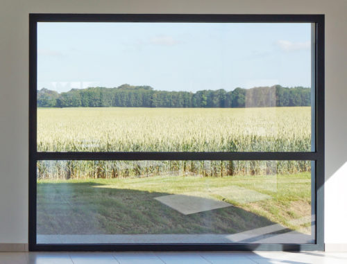Salle polyvalente par Atelier Cosme Architecture. Les baies cadrent la vue sur la campagne. Vue intérieure 2